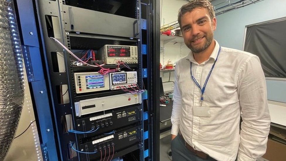 Richard Murray, CEO and Co-founder of ORCA Computing standing beside a quantum computer